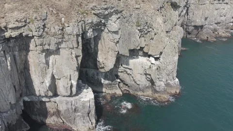 Aerial view of towering limestone cliffs and coastal sea caves at Swanage Stock Footage 342764968