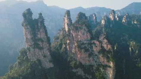 Aerial View of Towering Stone Pillars Rising Through Misty Subtropical Forest Video stock 341920724