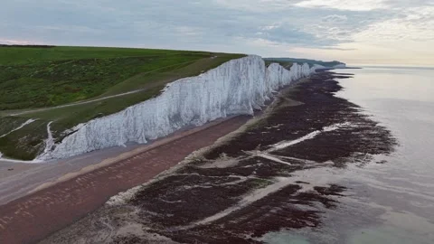 Aerial view of towering white cliffs and tranquil ocean shoreline Stock Footage 309764979