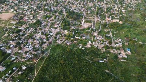Aerial view of a town bordering a dense forest, showing urban and natural Stock Footage 318728139