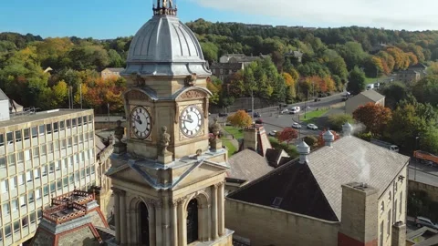 Aerial view of a town clock tower, surrounded by autumn trees 스톡 동영상 343690226