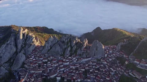 Aerial view of town with mountain backdrop and dramatic clouds, Italy. Stock Footage 279762729