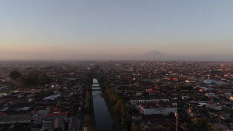 Aerial View of Town with River and Volcano at Dawn, Bali Video stock 337606983