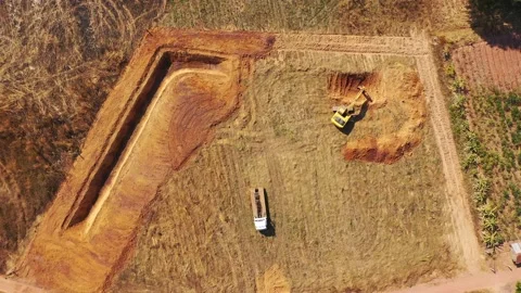 Aerial view, A trackhoe is digging the pond. Stock Footage 236928789