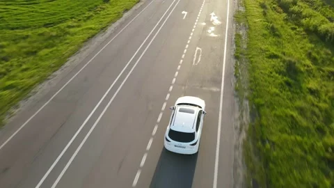 Aerial view tracking after suv car moving by speedway on sunset Stock Footage 155094092