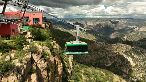 Aerial view tracking a cable car leaving the top station in Copper Canyon Stock Footage 332528265