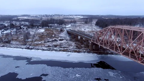 Aerial view tracking from a drone behind a railway train moving on a bridge Video stock 122427379