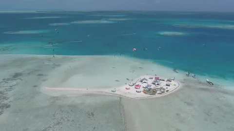 Aerial view tracking left Of Group Kitesurfing  in a paradisiac beach Vídeo Stock 142644748
