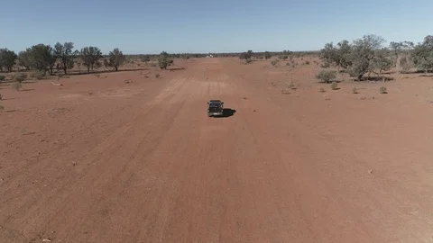 Aerial view tracking SUV ute car on dirt strip outback Stock Footage 92520254