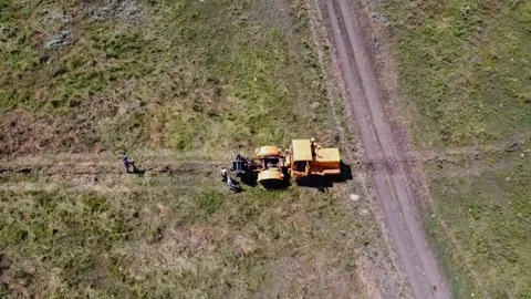 Aerial view of tractor with cable drum laying fiber optic hawser at countryside Stock Footage 300853054