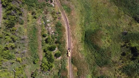 Aerial view of tractor with a cable drum laying fiber optic hawser at Stock Footage 333694987