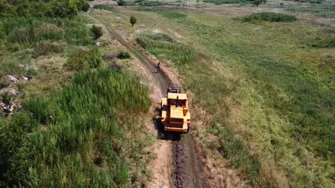 Aerial view of tractor with a cable drum laying fiber optic hawser at Stock Footage 333979351