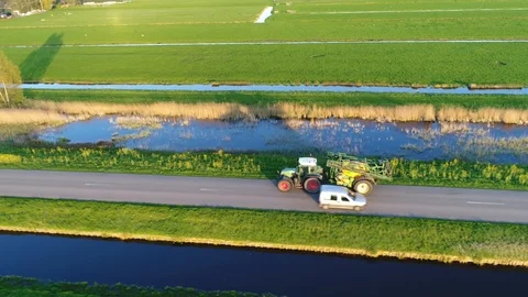 Aerial view of tractor carrying farm implement driving fast over public road Stock Footage 101051908