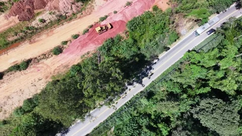 Aerial view of a tractor in a construction area beside a road with vehicles Stock Footage 332873388