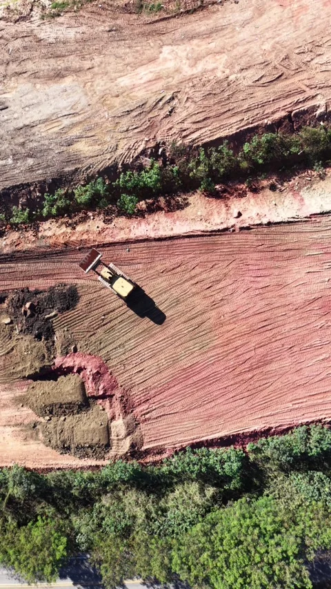 Aerial view of a tractor in a construction area beside a road Stock Footage 339080290