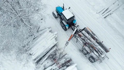 Aerial view tractor with a crane loads a trailer. Shoot drone Stock Footage 169548620