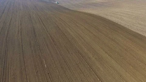 Aerial view of a tractor cultivating a fields with black soil for planting in 4K 動画素材 74143465