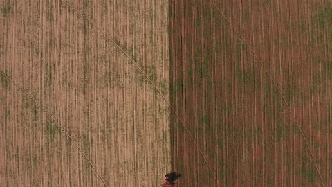 Aerial view tractor cuts furrows in farm field for sowing farm tractor with Stock Footage 145519040