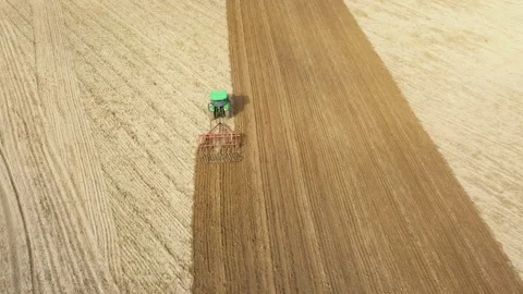Aerial view tractor cuts furrows in farm field for sowing farm Stock Footage 176530475