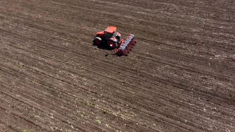 Aerial view tractor cuts furrows in farm field for sowing. Agricultural machine Stock Footage 248027609