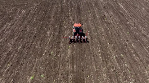 Aerial view tractor cuts furrows in farm field for sowing. Agricultural machine Stock Footage 258329160