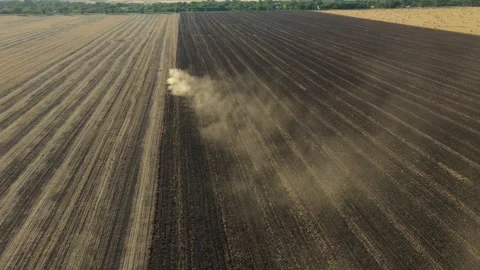 Aerial view of tractor as dragging a disc harrow over agricultural field Stock Footage 300245744