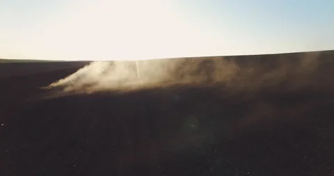 Aerial view of tractor in the dust working in the field at sunset.  Vidéo 132105674