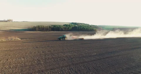 Aerial view of tractor in the dust working in the field . Vidéo 132131970