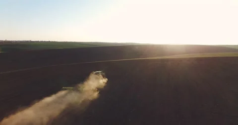 Aerial view of tractor in the dust working in the field . Vidéo 132132628