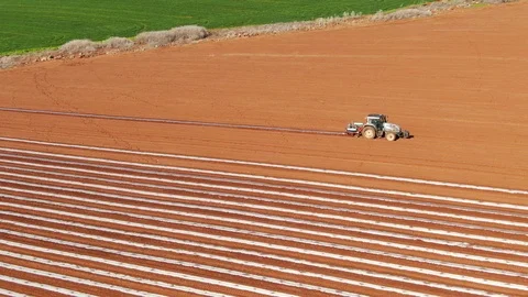 Aerial view of a tractor laying plastic mulch Stock Footage 125845951