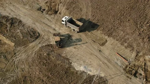 Aerial view of a tractor that loads soil into the back of a truck. Road works Stock Footage 227113651