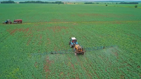 Aerial view of a tractor machine spraying the field with pesticides. Farm Stock Footage 197059256