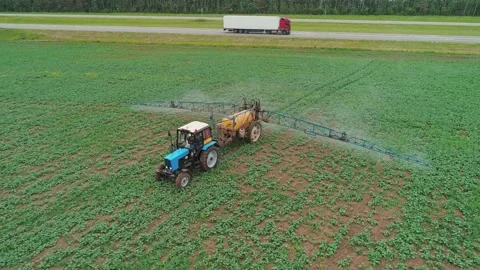 Aerial view of a tractor machine spraying the field with pesticides. Farm Video stock 197059331