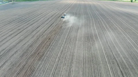 Aerial view of tractor with mounted seeder on plowed agricultural field. Stock Footage 130639913