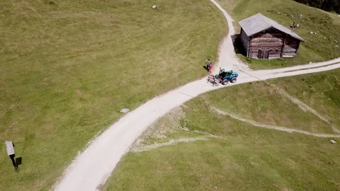 Aerial view of a tractor moving on a Dolomites Alpine road Stock Footage 114129750