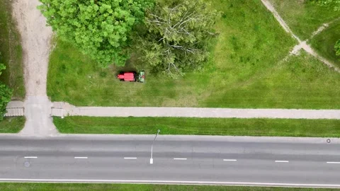 Aerial view of a tractor mowing grass in a lush green fieldAerial view of a.. Stock Footage 284875786