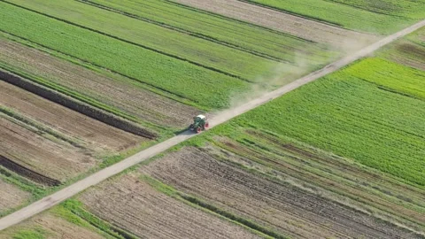 Aerial view of tractor passing the fields in rural environment in spring time Stock Footage 274300938