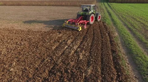 Aerial view of tractor plowing field at sunset Stock Footage 54990853