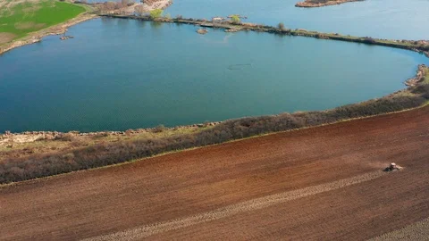 Aerial view of tractor plowing a field Stock Footage 105292545
