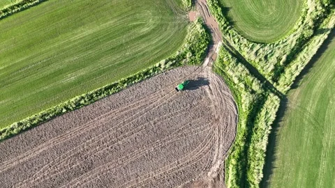 Aerial view of tractor plowing a field at sunset Stock Footage 250422553