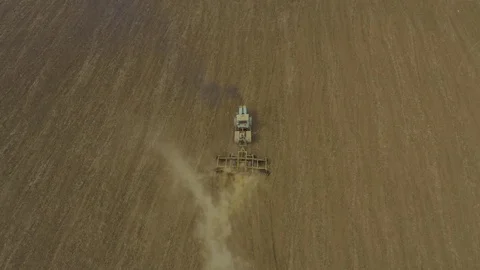 Aerial view tractor plows a large field. Dust in shot. Stock Footage 118742959