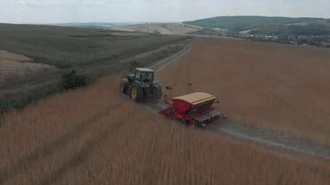 Aerial view of tractor pulling a machine behind Stock Footage 95325057