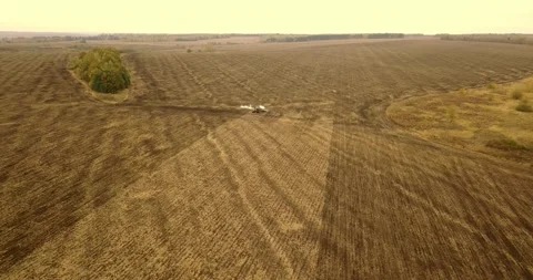 Aerial view of a tractor pulling a plow and an anhydrous tank of ammonia in a Stock Footage 157355119