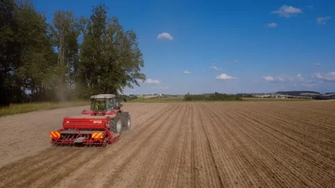 Aerial view of a tractor with a seed drill sowing a field in summer Vidéo 340514923