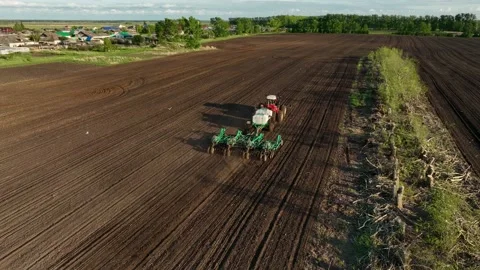Aerial View Tractor Sowing Seed On Plowed Field In Spring. Farming And Seeding Stock Footage 232118580