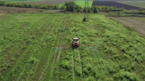 Aerial view on tractor as spraying field with sprayer, herbicide and pesticide Stock Footage 299905511