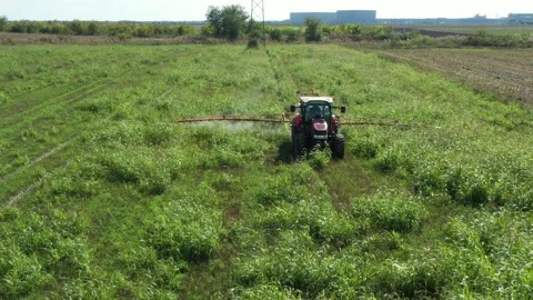 Aerial view on tractor as spraying field with sprayer, herbicide and pesticide Stock Footage 299906000