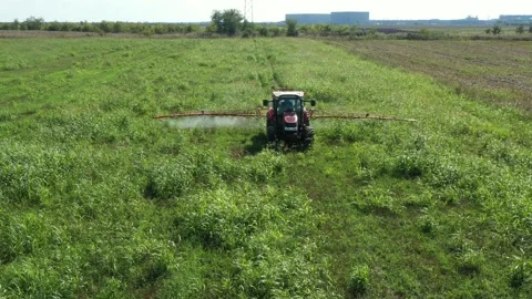 Aerial view on tractor as spraying field with sprayer, herbicide and pesticide Stock Footage 299906146