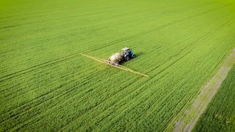 Aerial view of tractor spraying wheat field for increase yields Stock Footage 107941747