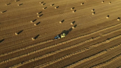 Aerial view of tractor tow trailed bale machine to collect straw Stock Footage 300245818